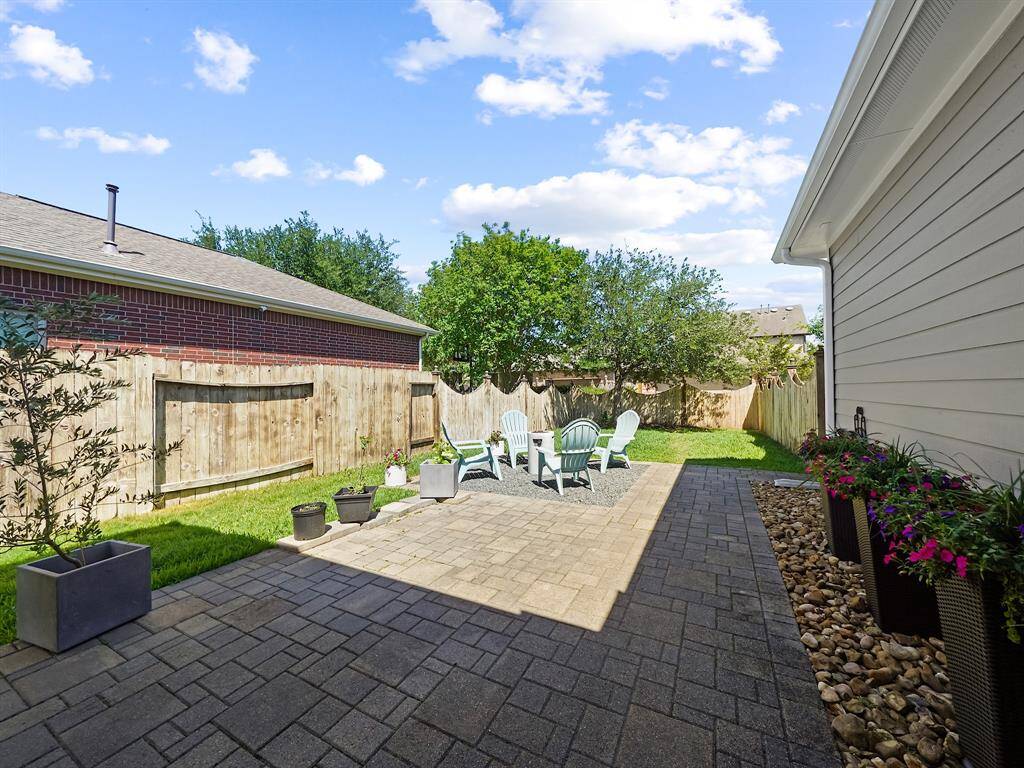 Beautiful pavers extend the patio, creating a seamless transition to a dedicated firepit area that you could recreate! (fire pit is excluded from sale)