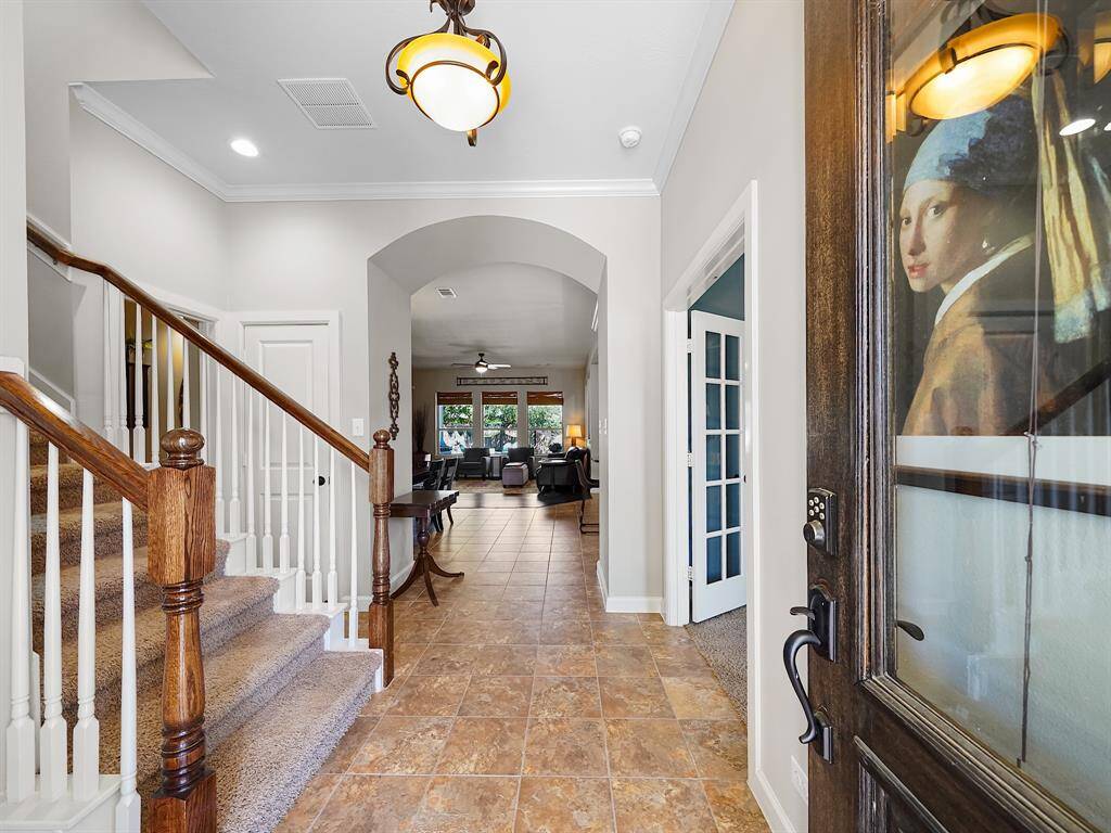 As you enter, you'll be greeted by a grand foyer that showcases high ceilings, accented by intricate crown molding, creating an immediate sense of grandeur.