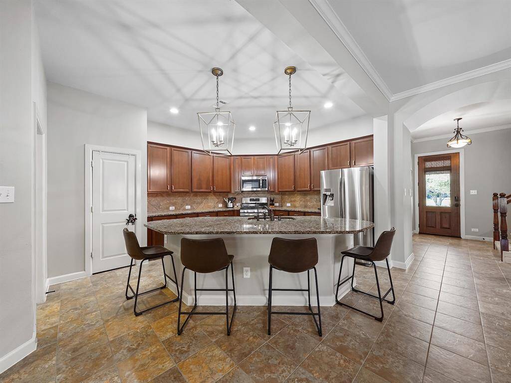 The heart of this home lies in its gourmet island kitchen, a culinary masterpiece designed for both functionality and style.
