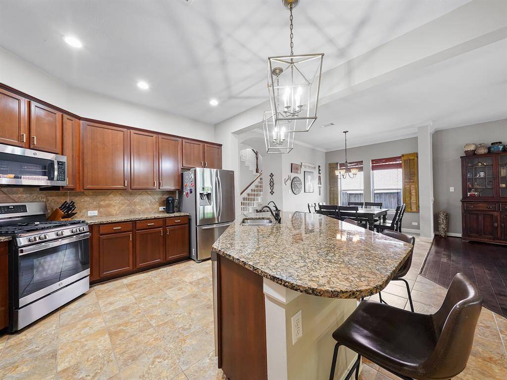 The sleek granite countertops, complemented by a stylish tile backsplash and stainless steel appliances, create a chef's paradise