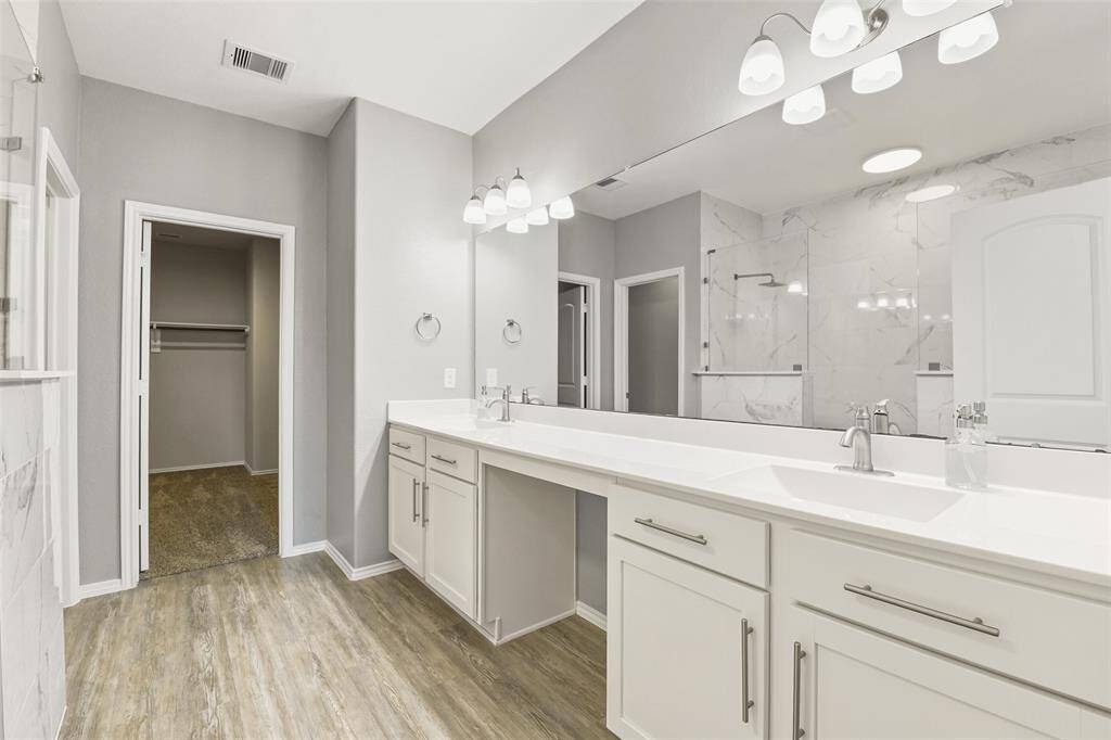 Primary Bathroom includes dual sinks, dual walk-in shower, vanity, and huge walk-in closet.