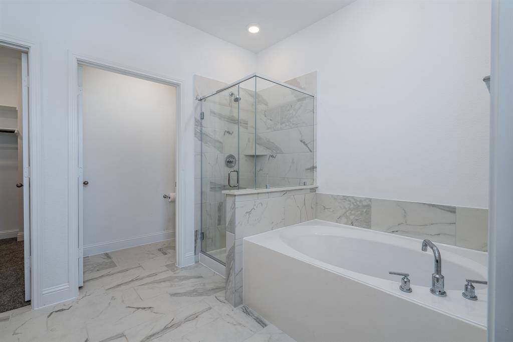 The primary bathroom on the first floor with separate tub and shower.