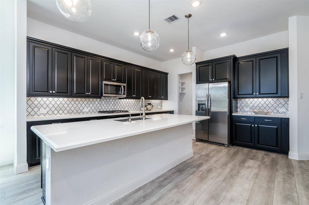 Quartz counters, stainless appliances and a gorgeous backsplash compliment this chef's kitchen.