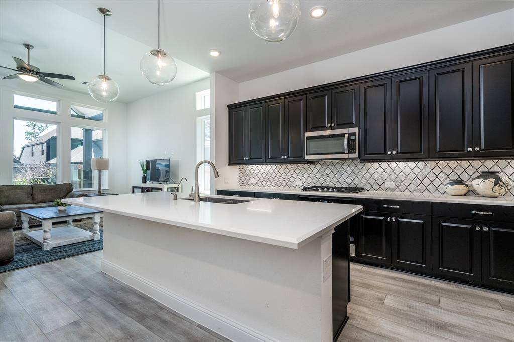 Notice all the counter space and how the room flows into the living room with its floor to ceiling windows allowing all the light to permeate the home.