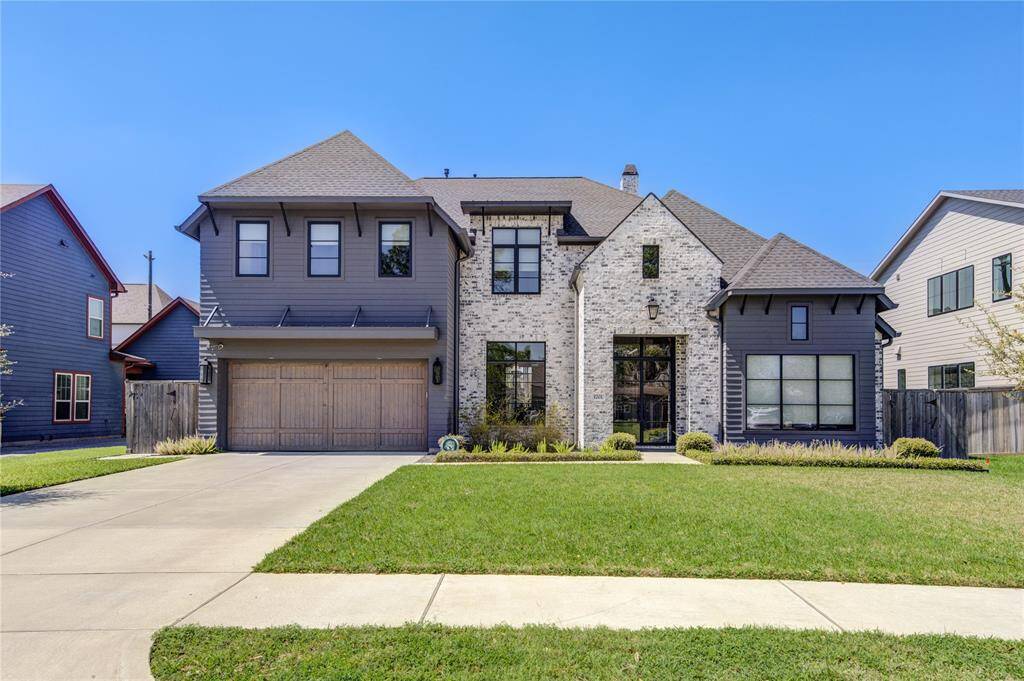 This modern two-story home features a blend of brick and dark siding, a spacious two-car garage, and a well-maintained front lawn. The elegant design includes large windows for natural light and a welcoming entrance.