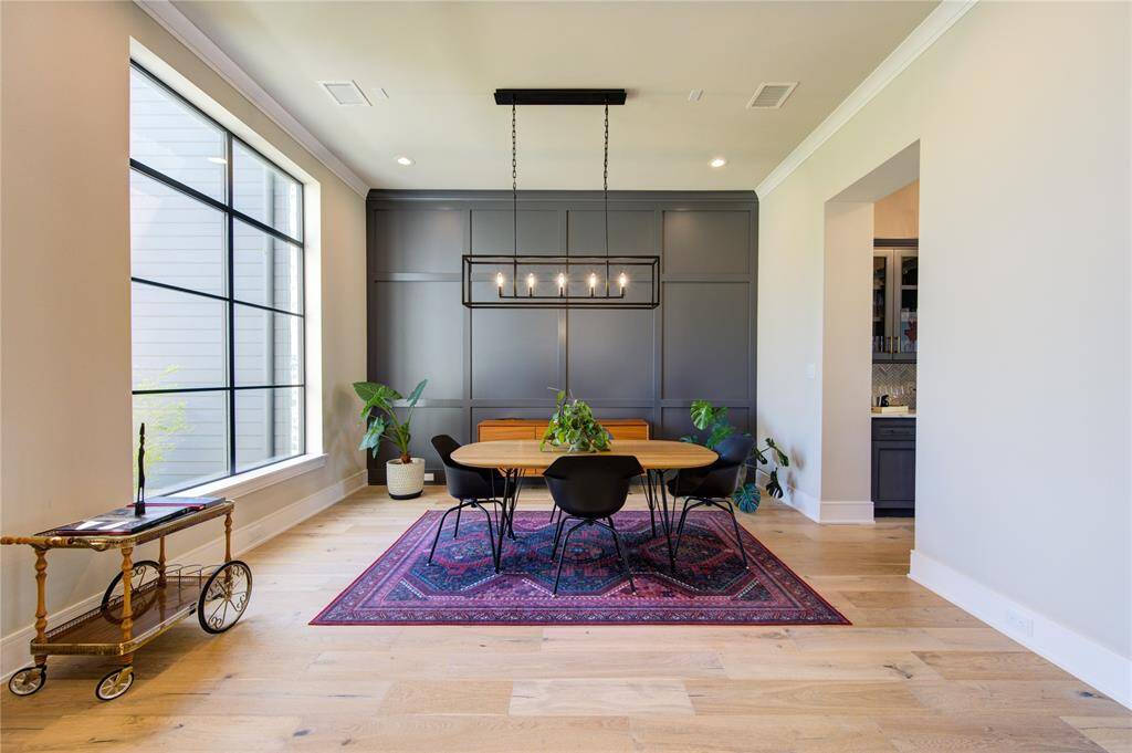 Experience the elegance of this spacious dining room, featuring a striking concept wall for a modern touch.