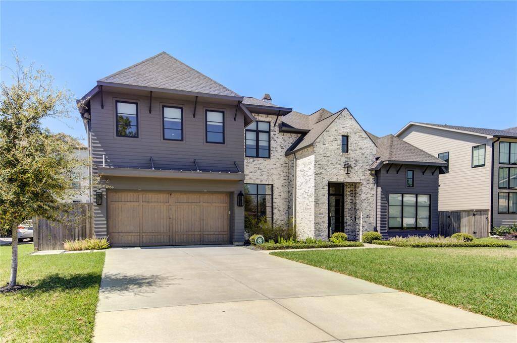 This beautiful two-story home features a modern design with a combination of brick and siding exterior. It includes a spacious two-car garage and a well-maintained front yard with a landscaped garden. The large windows provide ample natural light, and the driveway offers additional parking space.