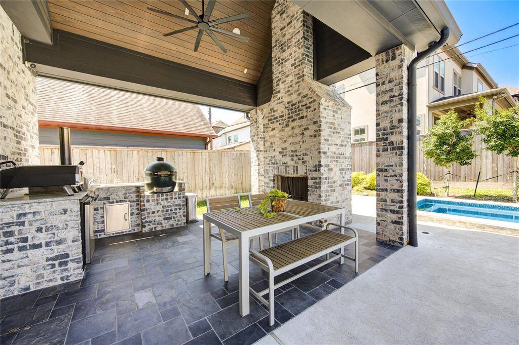 Experience luxury outdoor living with a stunning kitchen and cozy fireplace, perfect for entertaining and relaxation.