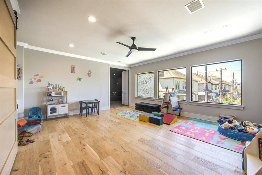 Spacious and bright game room featuring large windows, perfect for family fun and relaxation.