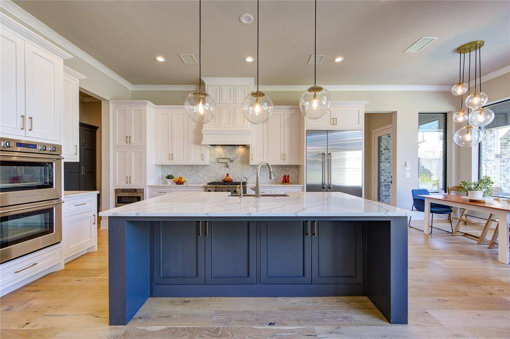 Chic and spacious kitchen featuring modern cabinetry, sleek countertops, and elegant pendant lighting. Perfect for culinary adventures and entertaining guests.