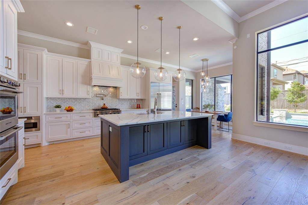 Another view of this spacious and elegant kitchen with sleek countertops, modern appliances, and abundant natural light. Perfect for culinary enthusiasts and entertaining.