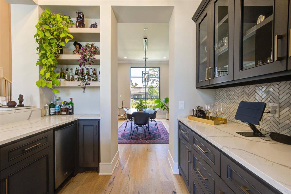 Stylish wet bar with sleek cabinetry, open shelving, and elegant countertops—perfect for entertaining.