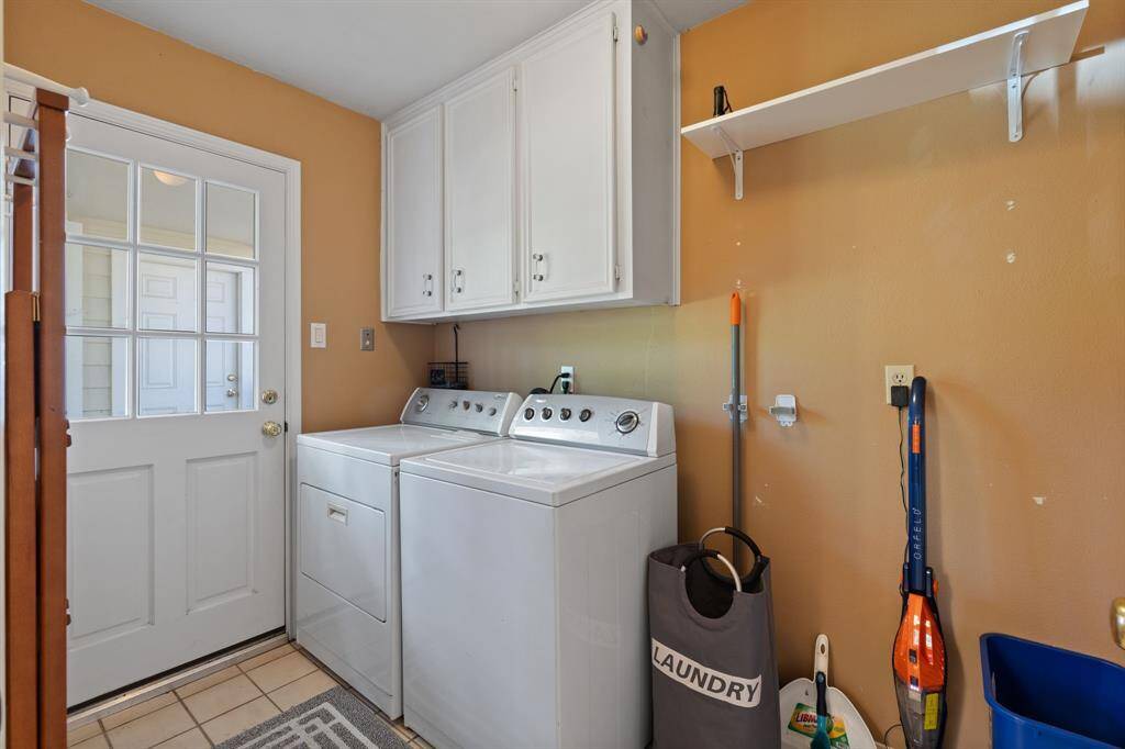 Laundry room with a door that leads outside and...