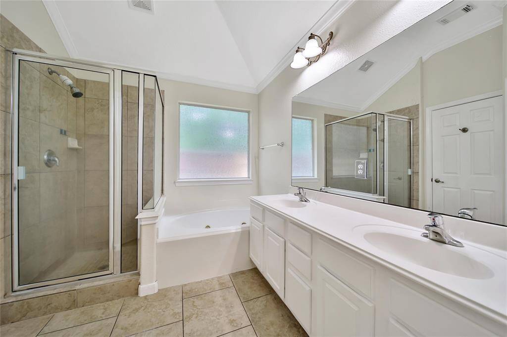 The primary bath features separate jetted tub and shower, and dual sinks.
