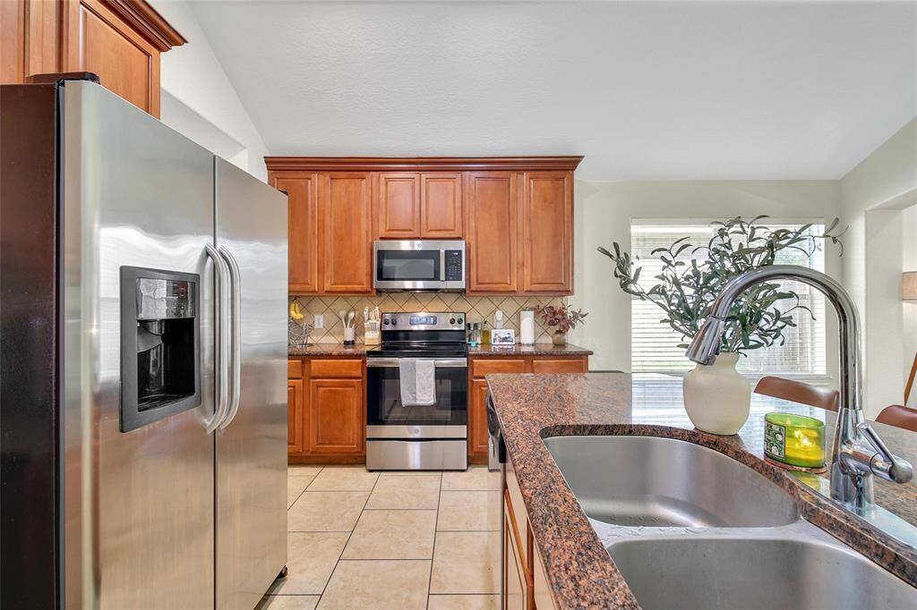 The kitchen features granite counters, a large island with breakfast bar seating, and ample counter and cabinet space.