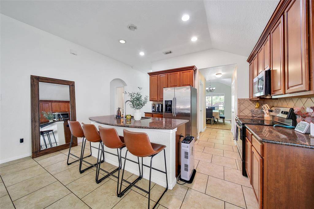 Here you can see the curved breakfast bar on the kitchen island. The hallway to the right leads to the dining room with the pantry on the right, and utility room on the left.