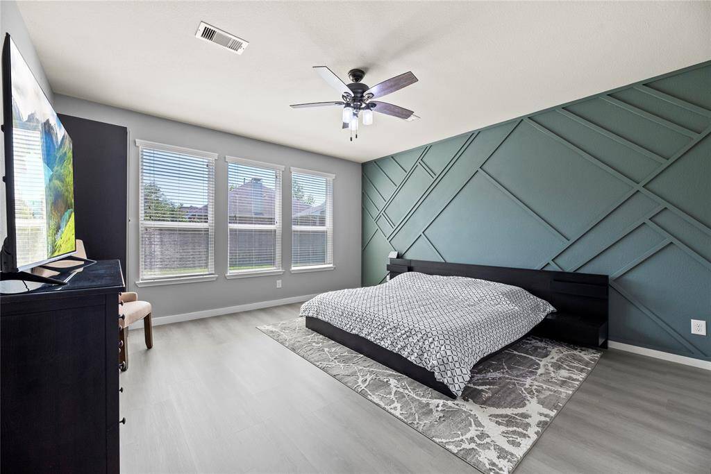 The serene primary bedroom with a beautiful custom accent wall and an abundance of space for all your bedroom furniture.
