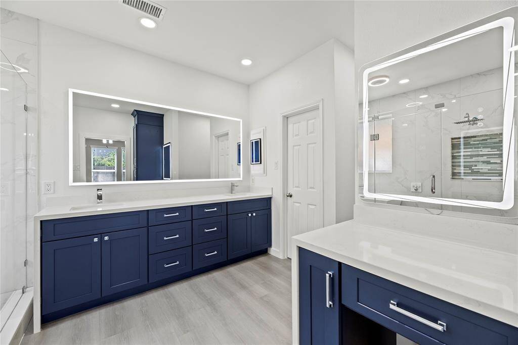 Custom cabinetry, fogless LED lighted mirrors and recessed lighting featured here.