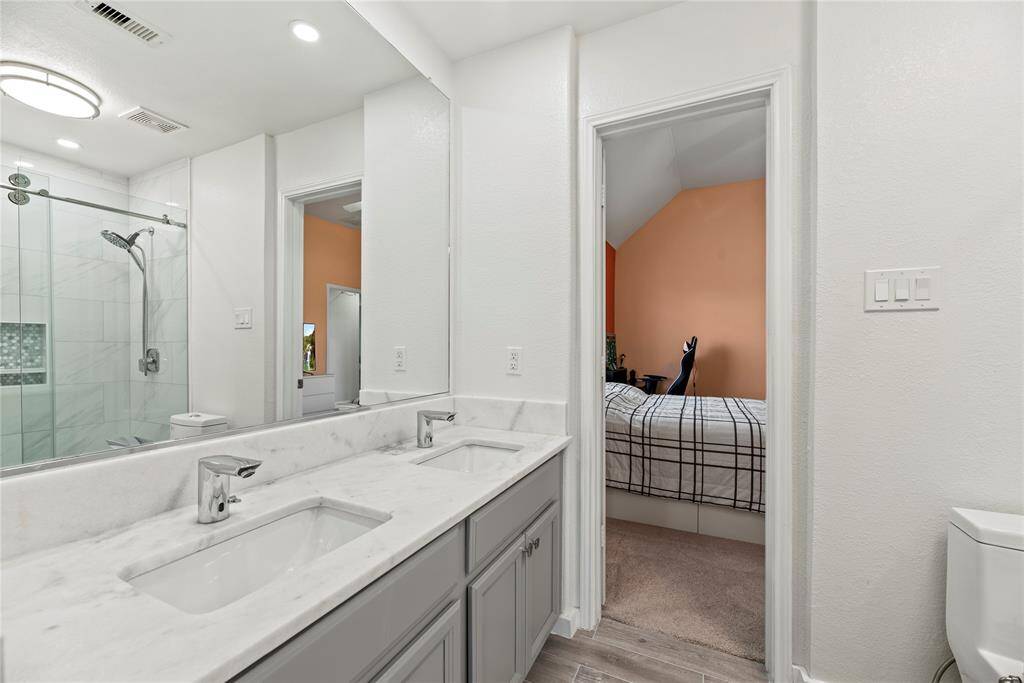 Jack and Jill bath connecting 2 secondary bedrooms.  Fully remodeled as well with sleek quartz counters.