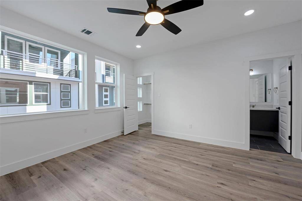 This oversized bedroom across the hall from the primary bedroom also has large windows, upgraded floors, and a ceiling fan. No carpet here either.