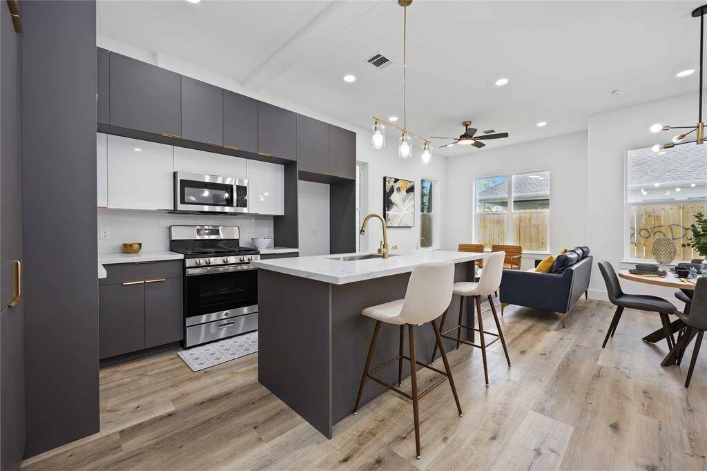 Stainless steel appliances, dual toned cabinets, and recessed lighting add to the modern feel of the home. Oversized windows bring in ample natural light.