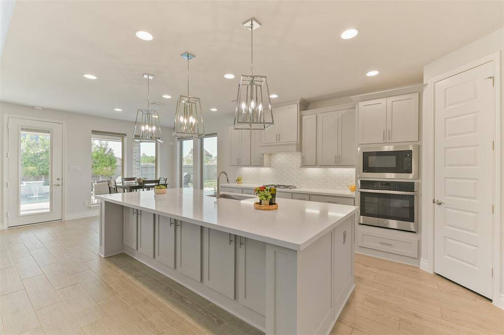 A walk-in pantry is conveniently located in the corner of the kitchen, close to refrigerator, oven, and island.