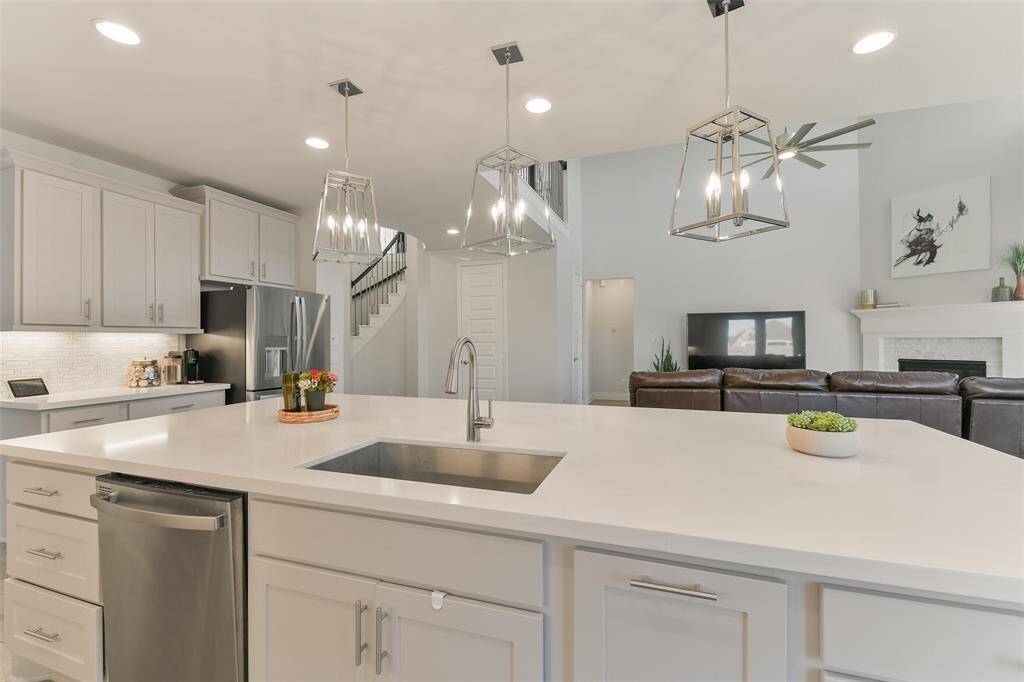 Single bowl kitchen sink is large enough for a party of dishes. Pendant lights add elegant lighting options.