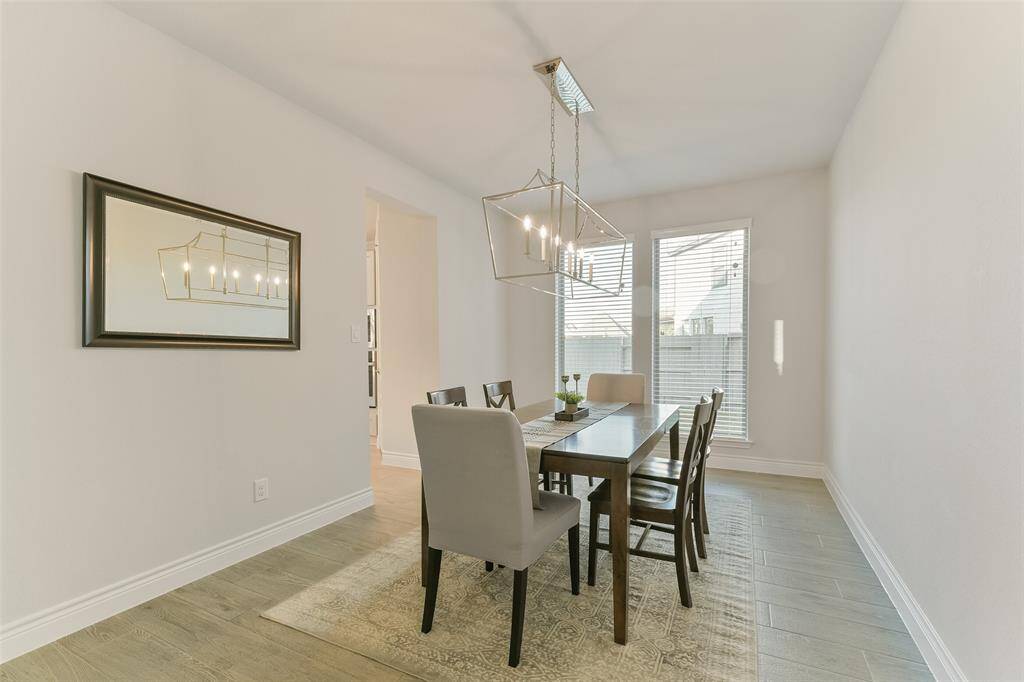 Formal dining with upgraded chandelier is large enough for big holiday dinners with windows looking to the spacious side yard.