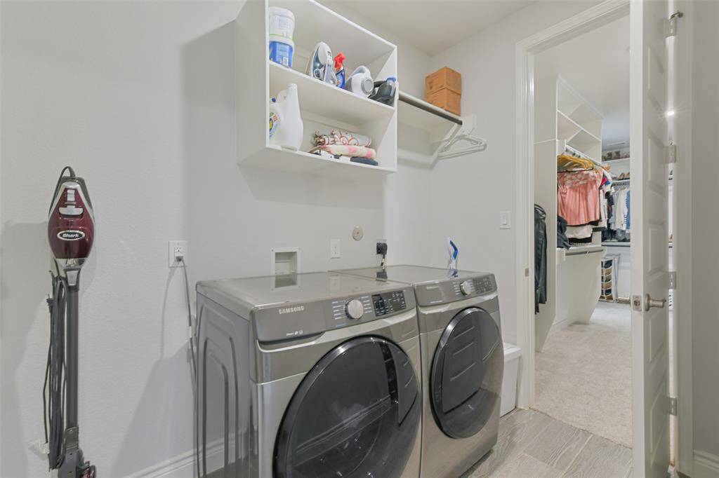 Spacious laundry room can be accessed from the entry hall or the enormous primary walk-in closet, making it easy to put away the clean clothes.