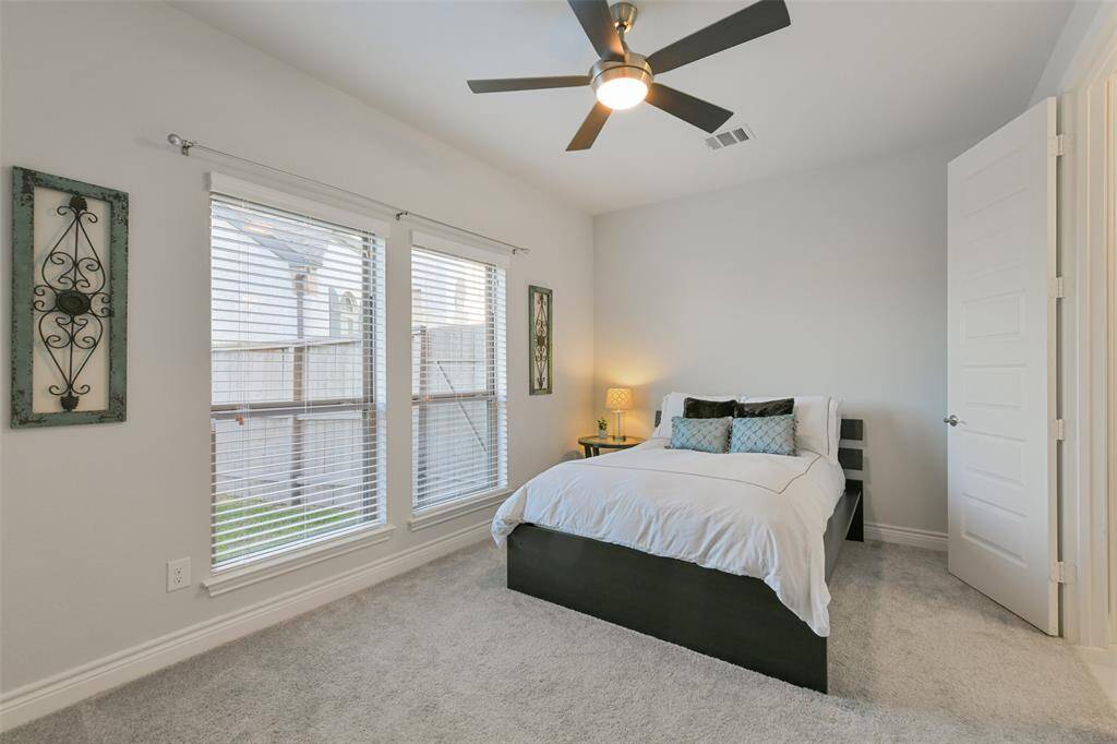 Large downstairs second bedroom has ceiling fan and double windows looking to the spacious side yard plus an ensuite bath.