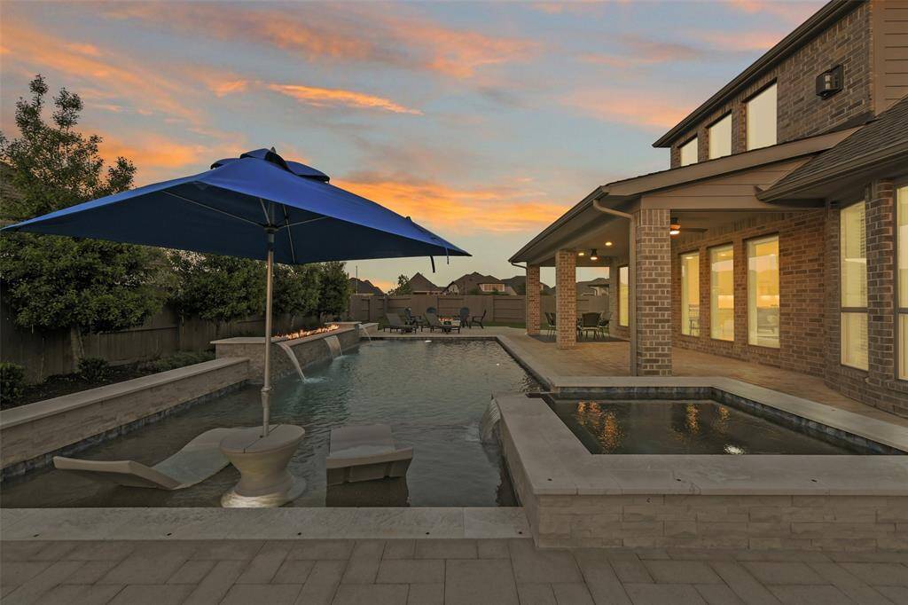 First glimpse of the gorgeous pool and spa, with its sunshelf, 4 waterfalls, and fire feature.