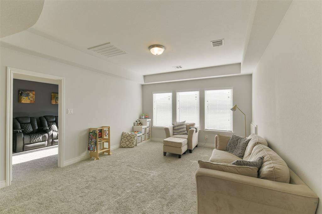 Spacious game room with wall of windows and trayed ceiling opens to the media room.