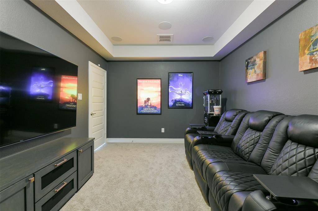 Media room with built-in cabinet also boasts surround sound speakers, smart switches, and lighted movie posters that stay with the home.