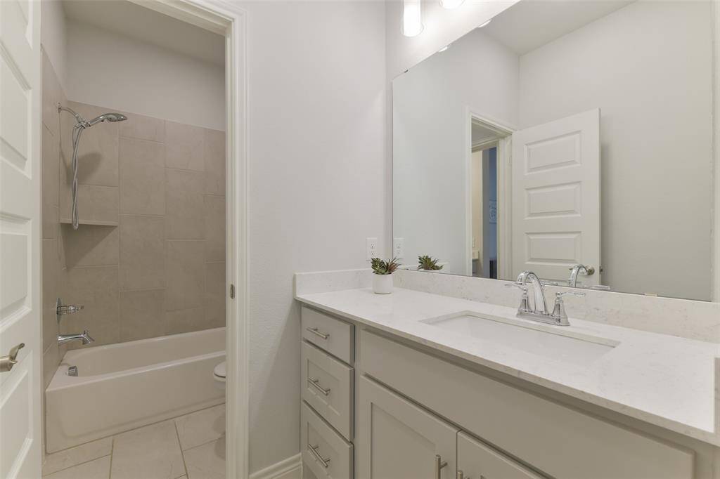 Hollywood bath with tub/shower combination connects to the hallway with a sink on one side and to the fourth bedroom with a sink on that side, as well.