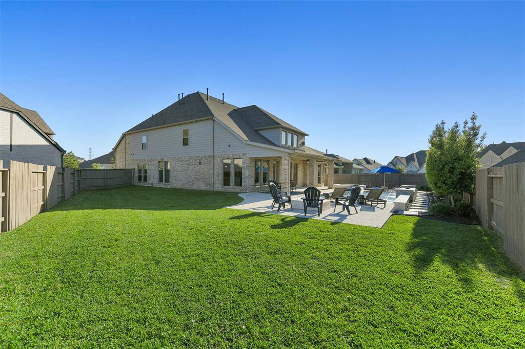 This backyard is so big, there is still plenty of room for dogs, children, or any other outdoor activities. A full sprinkler system helps keep the yard green, and French drains and full gutters keep water flowing away from the home. A stained fence adds to the upscale look of this outdoor space.