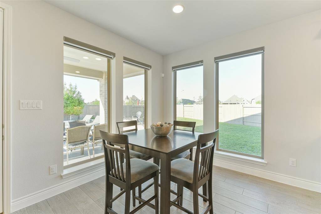 Breakfast area has views of the landscaped backyard and pool through multiple windows equipped with remote shades.
