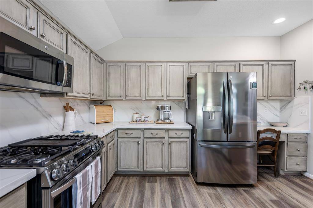 This kitchen has updated cabinets, counter tops and backsplash.