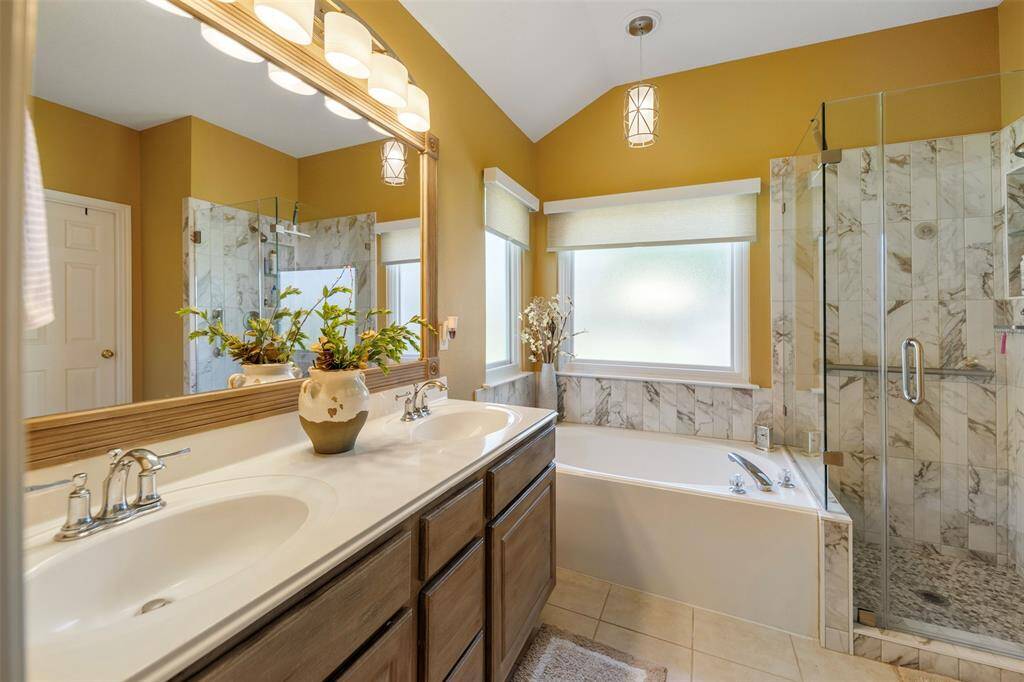 Primary bath features dual sinks, a soaking tub, and a separate shower.