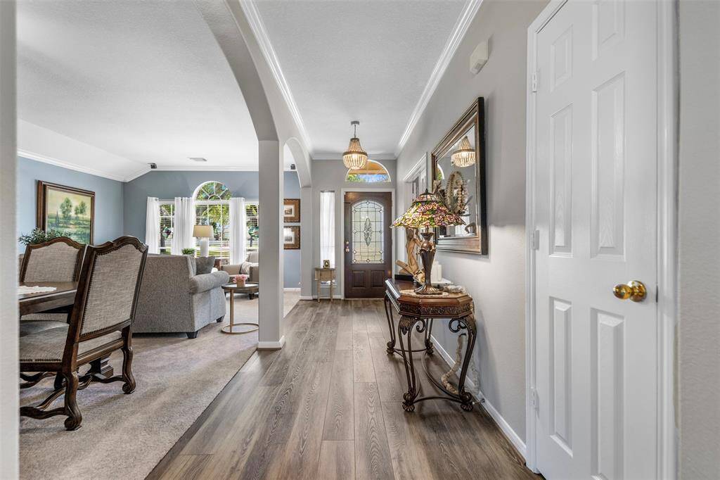 The stunning entry showcases updated flooring and new interior paint that flows into formal living and dining areas.