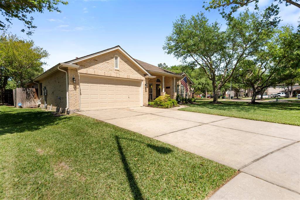 Extended driveway with side garage access and well-maintained landscaping.
