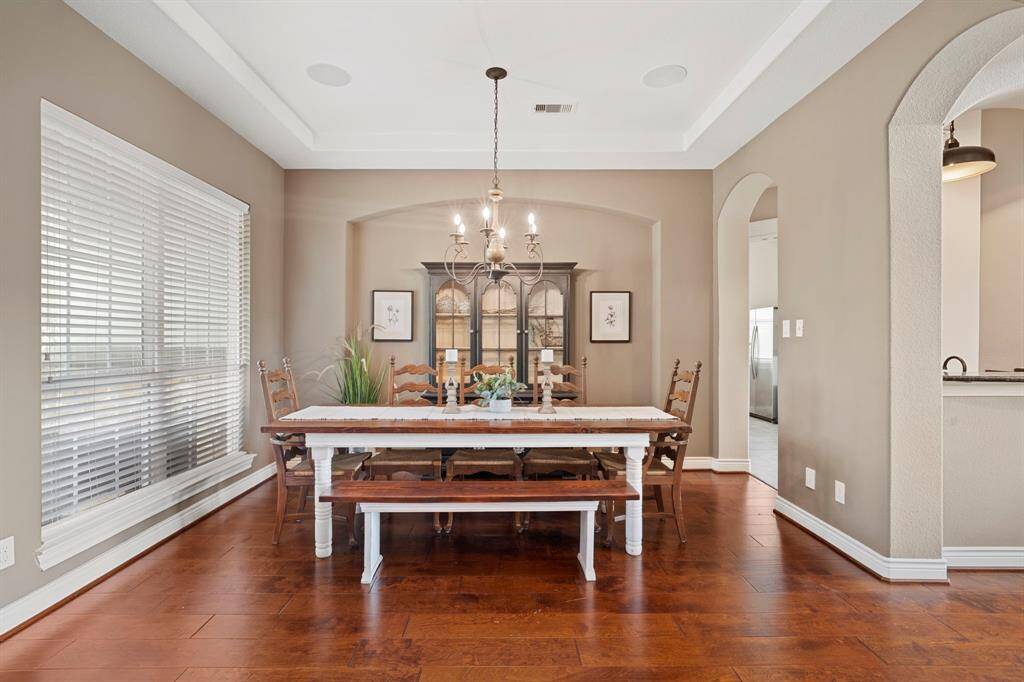 Elegant formal dining room with tray ceiling and charming archways—perfect for hosting memorable gatherings.
