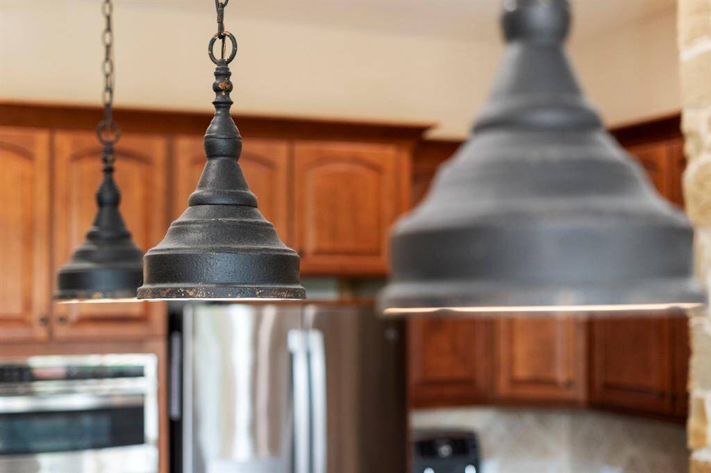 Stylish industrial pendant lighting adds a touch of character and warmth over the central island.