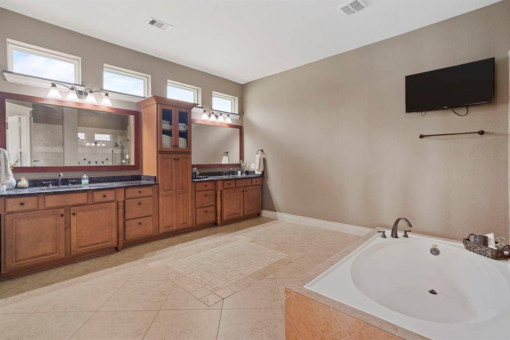 Spa-inspired ensuite with dual vanities, soaking tub, and ample storage for a private retreat for relaxation and rejuvenation.