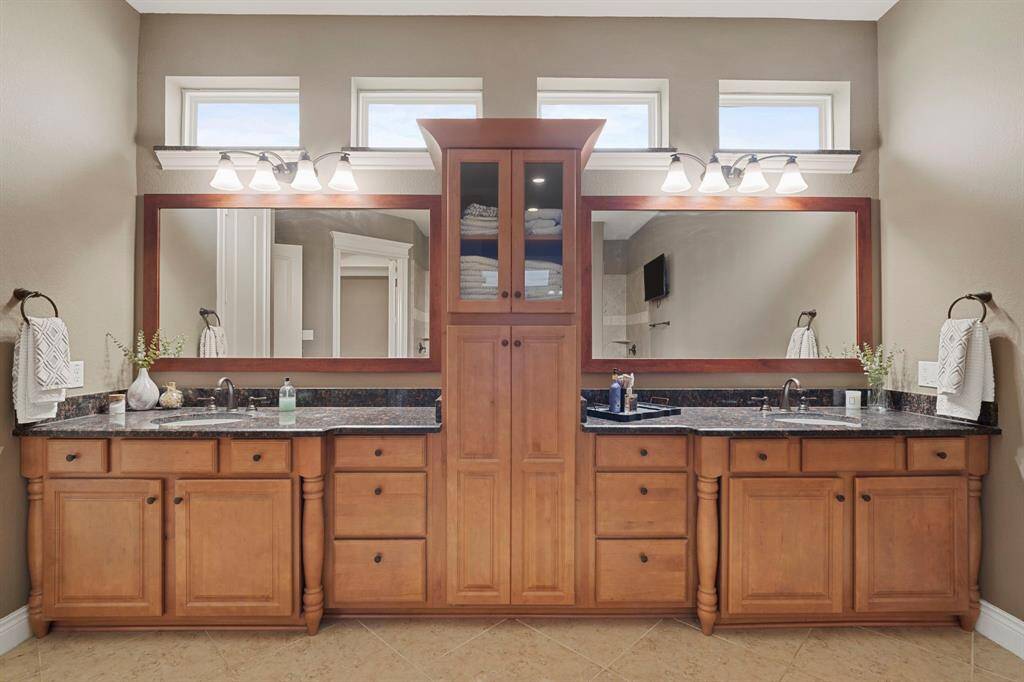 Dual sinks and abundant cabinetry provide function and luxury, beautifully illuminated by natural light through clerestory windows.