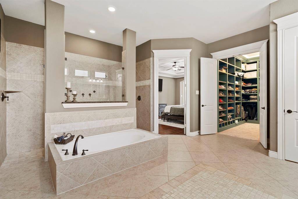 Expansive primary bath with soaking tub, walk-in shower, and direct access to a custom-designed closet—luxury and convenience in one.