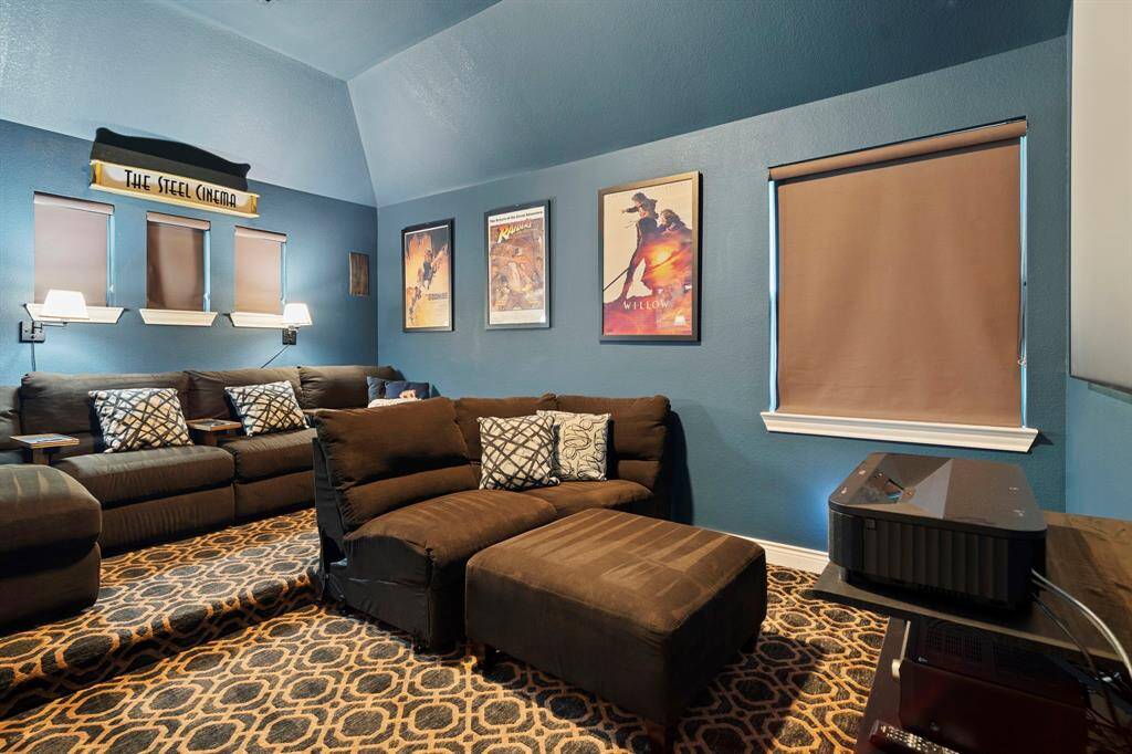 Enjoy movie nights in your very own home theater featuring tiered levels and custom wall décor.