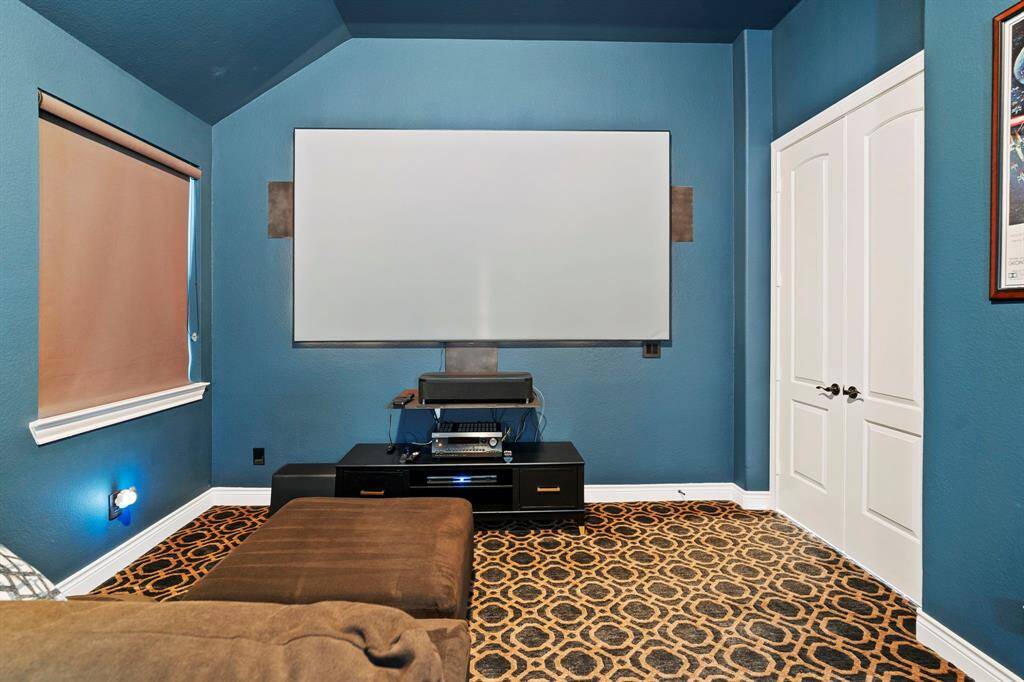 Media room with blackout shades and built-in surround sound for the ultimate cinematic experience.