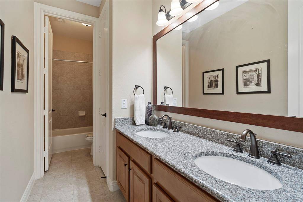 Stylish bathroom with granite countertops, double sinks, and private shower/tub area—perfect for busy mornings.