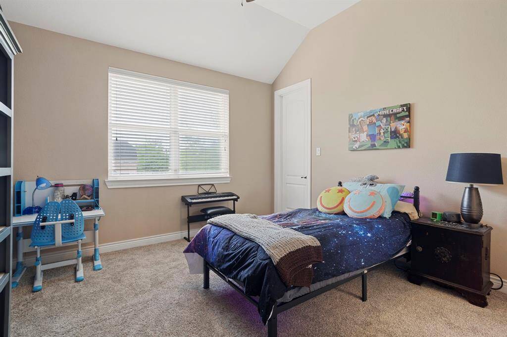 Bright and cheerful secondary bedroom with vaulted ceilings and ample space for rest, study or play.