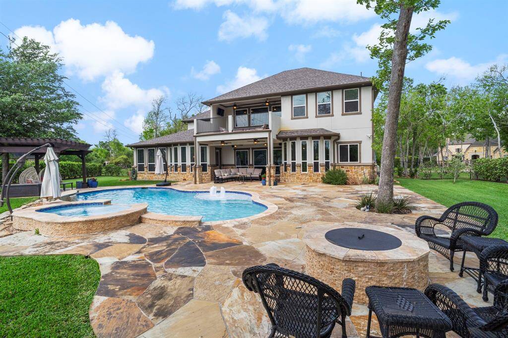 This entertainer’s paradise includes a spacious flagstone patio, pool and spa, shaded pergola, and a cozy fire pit for year-round enjoyment.